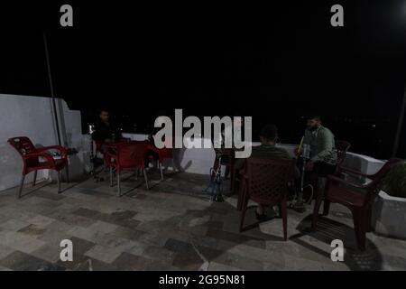 July 23, 2021: The pictures show a group of Syrian youths sitting on the top of Jabal Al-Arbaeen overlooking the city of Idlib and its countryside, where the mountain was a tourist destination before the Syrian revolution because of its beautiful and strategic location, after which it was subjected to intense bombardment by the regime forces, which led to the destruction of many buildings in it. Despite that, young people still go to spend Some time there despite the danger of bombing (Credit Image: © Moawia Atrash/ZUMA Press Wire) Stock Photo