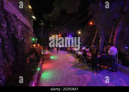 July 23, 2021: The pictures show a group of Syrian youths sitting on the top of Jabal Al-Arbaeen overlooking the city of Idlib and its countryside, where the mountain was a tourist destination before the Syrian revolution because of its beautiful and strategic location, after which it was subjected to intense bombardment by the regime forces, which led to the destruction of many buildings in it. Despite that, young people still go to spend Some time there despite the danger of bombing (Credit Image: © Moawia Atrash/ZUMA Press Wire) Stock Photo