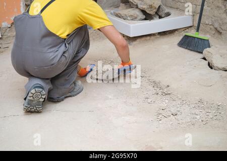 Close up of a young caucasian construction worker shoveling sand at a construction site. Stock Photo