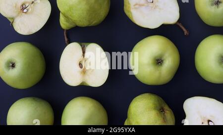 whole and cut apples and pears on a dark background Stock Photo