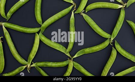 Triangle pattern from green peas on a dark background Stock Photo