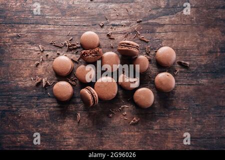 Chocolate macarons lying on wooden table Stock Photo