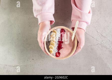 Hands holding berry smoothie bowl Stock Photo