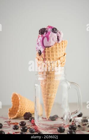 Homemade berry ice cream in a waffle cone standing in a glass jar Stock Photo