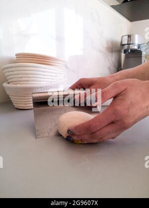 The baker works with the dough, the view from the side Stock Photo
