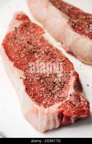 Raw cuts of seasoned flat iron steak Stock Photo
