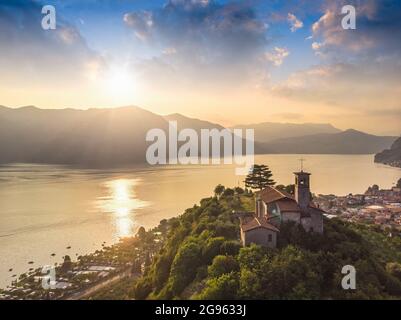 Beautifull aerial panoramic view from the drone to the Iseo lake with church on top of the hill, Lombardy, Italy