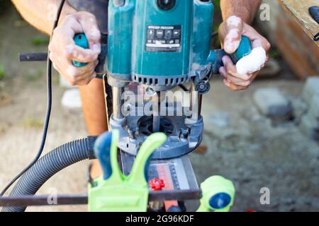 A carpenter works with a wood milling machine. Professional tools for woodworking. Stock Photo