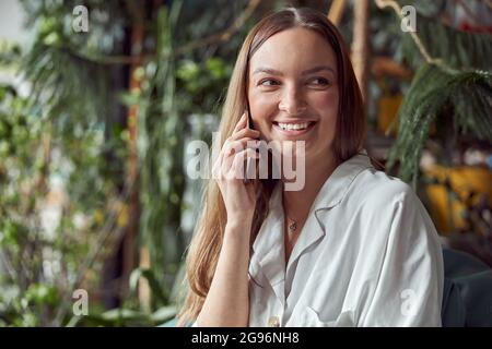 Young caucasian happy seller woman at botanic shop Stock Photo