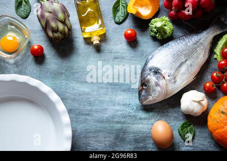 Food ingredients on black grunge  background with a white dish Stock Photo