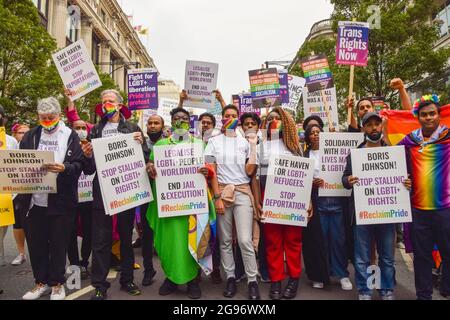 London, UK. 24th July, 2021. Demonstrators hold placards while marching on Oxford Street during the Reclaim Pride protest.Thousands of people marched through central London in support of LGBTQ  rights, diversity, inclusion, and against increasing transphobia, and what many see as the commercialisation of the annual Pride march. Credit: SOPA Images Limited/Alamy Live News Stock Photo