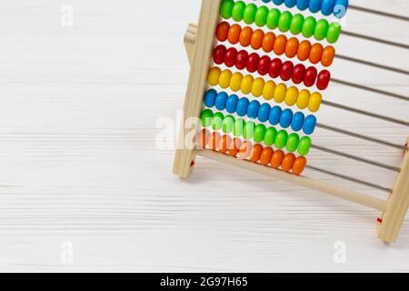 Wooden colorful abacus on wooden background. Back to school, education. Tool for calculation in kindergarten, preschool Stock Photo