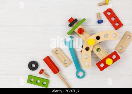 A colorful wooden building kit, plane for children on wood. Set of tools on white wooden table. Games and tools for kids in kindergarten, preschool Stock Photo