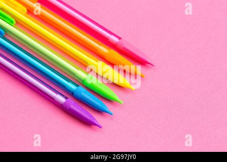 Background with Rainbow Mechanical Pencils on a Bright Pink Table Great for Back to School Stock Photo
