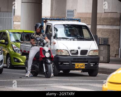 Medellin, Colombia - July 21 2021: Afro American Man Waits on a Motorcycle at the Traffic Lights Stock Photo