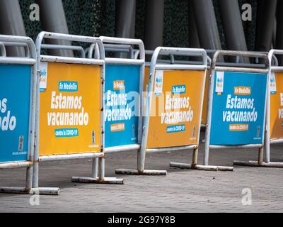 Medellin, Colombia - July 21 2021: Various Barriers for Waiting Line for Vaccination with Banners that Read: 'In Medellin, We're Vaccinating Against C Stock Photo