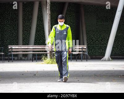 Medellin, Colombia - July 21 2021: Young Latin Men in a Fluorescent Outfit Walks in a Public Park and Stares Stock Photo