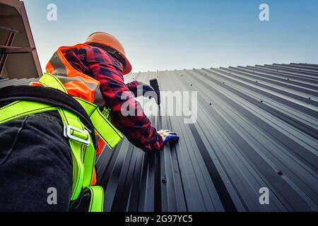 Worker man building tradesman on the roof of a house   with safety helmet, new home, construction concepts - Selective focus. vintage film grain filte Stock Photo