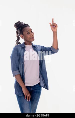 Confident African American woman pointing up and looking at camera Stock Photo