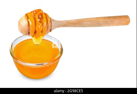 Honey with glass bowl and wooden spoon isolated on white background. Honey clipping path. Stock Photo