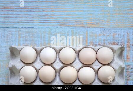 Box of white eggs on wood background. Top view, copy space. Stock Photo