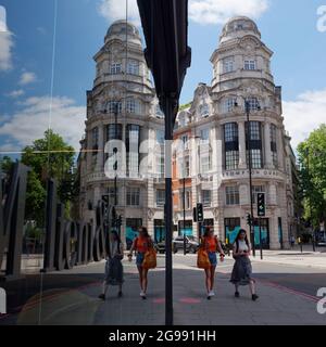 London, Greater London, England, June 12 2021: Mirror image of Brompton Quarter Empire House with two women in foreground. Stock Photo