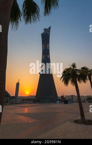 Doha, Qatar – October 1, 2019: The Torch Tower in Doha Sport City Complex at sunset next to Aspire Masjid Mosque against clear sky Stock Photo