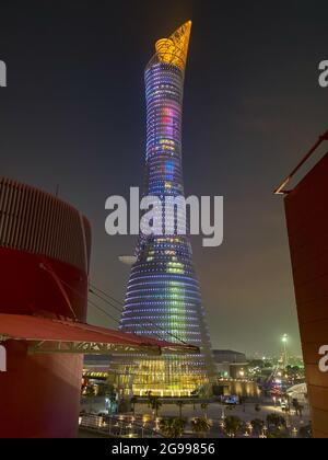 Doha, Qatar – September 26, 2019: The illuminated Torch Tower in Doha Sport City Complex at night against dark sky Stock Photo