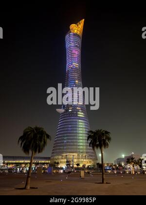 Doha, Qatar – September 26, 2019: The illuminated Torch Tower in Doha Sport City Complex at night against dark sky Stock Photo