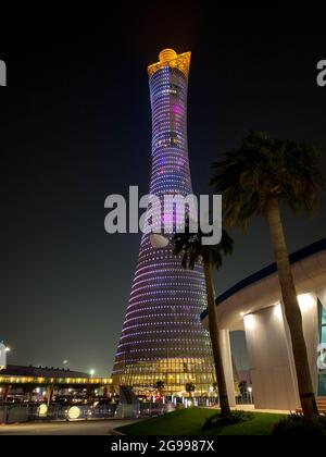 Doha, Qatar – September 29, 2019: The illuminated Torch Tower in Doha Sport City Complex at night against dark sky Stock Photo