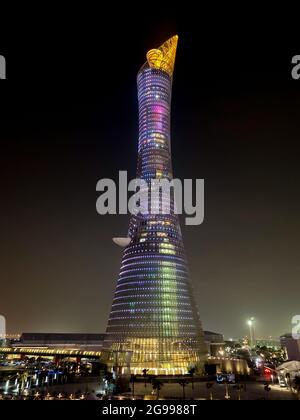 Doha, Qatar – September 26, 2019: The illuminated Torch Tower in Doha Sport City Complex at night against dark sky Stock Photo