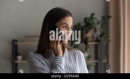 Happy beautiful woman talks on the phone looking away Stock Photo