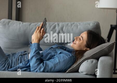 Woman relax indoor use cellphone spend free time on internet Stock Photo