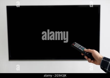 Blank TV Screen And Hand With Television Remote Control Indoor Stock Photo