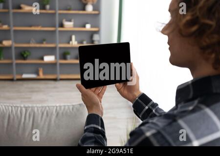 Man Using Tablet Computer With Empty Screen Controlling House Indoors Stock Photo