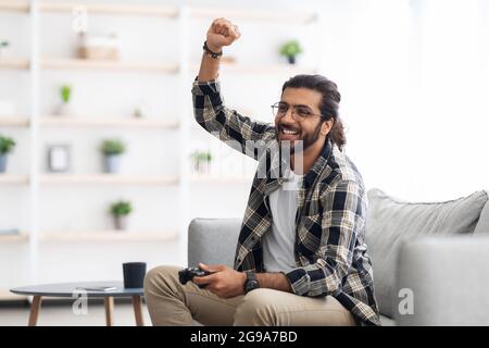Emotional middle-eastern man playing video games at home Stock Photo