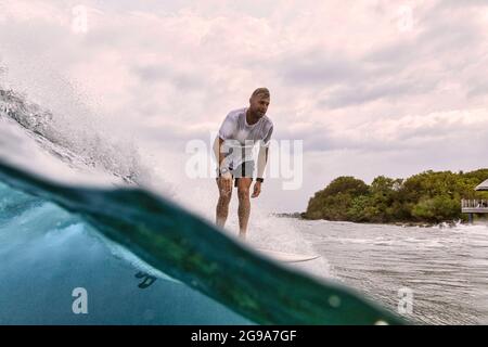 Surfer on a wave, Maldives, Indian ocean Stock Photo