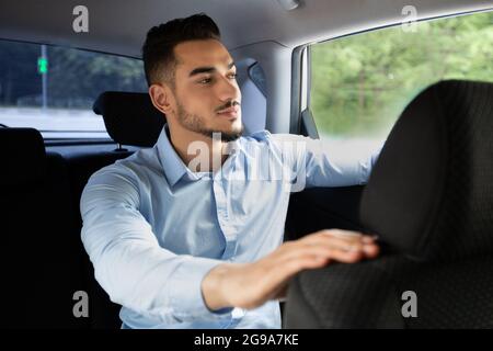 Handsome arab businessman going to office by taxi Stock Photo