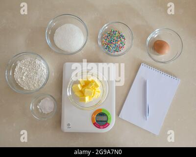 6 bowl of ingredients, bowl on digital kitchen scale, notepad and pen Stock Photo
