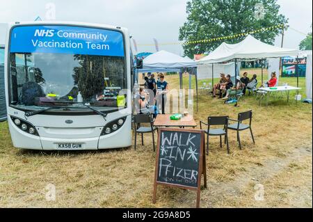 Henham Park, Suffolk, UK. 25th July, 2021. Pfizer vaccines (both first and second doses) are given out from an NHS Community Vaccination Team bus - The 2021 Latitude Festival, Henham Park. Suffolk, returns as a covid test event after a year off due to the pandemic. Credit: Guy Bell/Alamy Live News Stock Photo