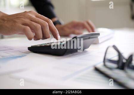 business accounting concept, business man using calculator with computer laptop, budget and loan paper in office. Stock Photo