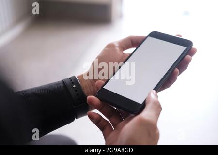 Close up of man hand holding smart phone. Blank screen mockup for graphics display montage. Stock Photo