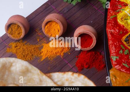 Indian Colourful Spices Also Know as Red Chilli Powder, Turmeric Powder, Coriander Powder, Mirchi, Mirch, Haldi, Dhaniya Powder Isolated on wooden Bac Stock Photo