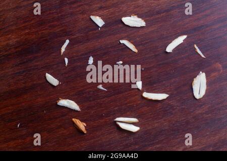 Chopped almonds particles on wooden background. Stock Photo