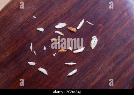 Chopped almonds particles on wooden background. Stock Photo