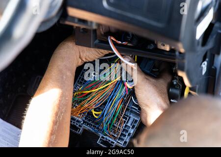 Auto technician diagnose and fixing wiring problem of car Stock Photo