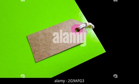 Blank brown cardboard price tag or label on green and black background. view from above. Stock Photo