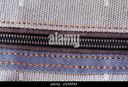 A zipper, zip, fly, or zip fastener, known as a clasp locker, is a commonly used device for binding the edges of an opening of fabric. Close-up. Stock Photo