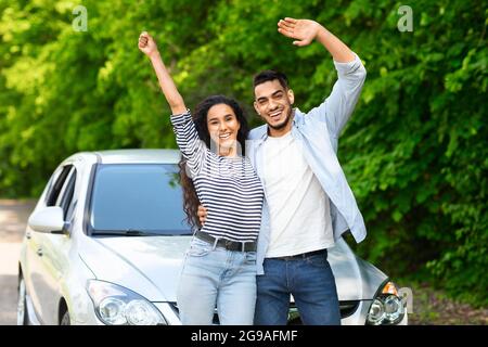 Emotional multiracial couple standing by nice auto Stock Photo
