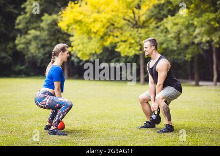 Fit couple lifting kettle bells in the gym Stock Photo